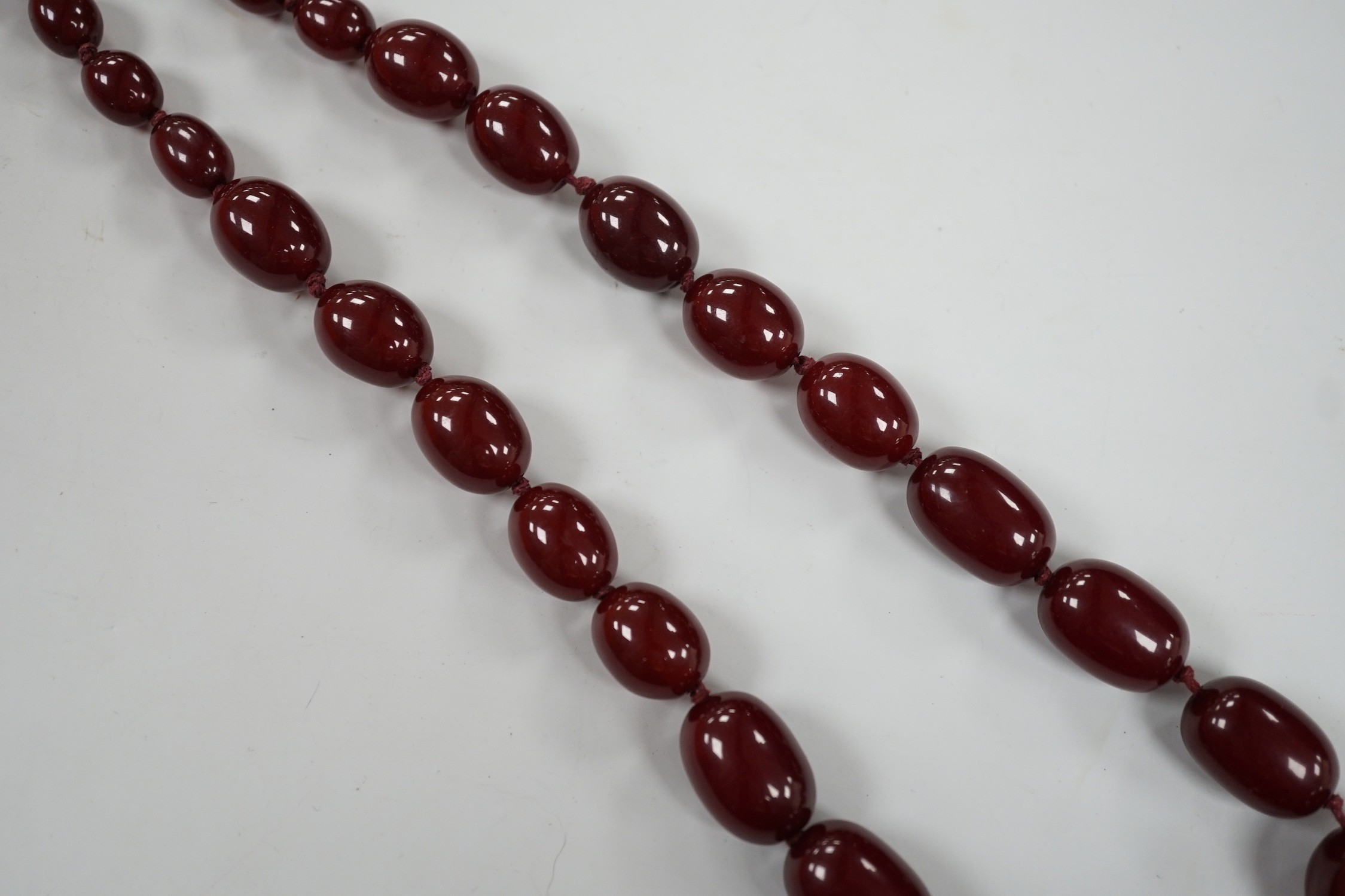 A single strand graduated simulated cherry amber necklace, 82cm, gross weight 83 grams.